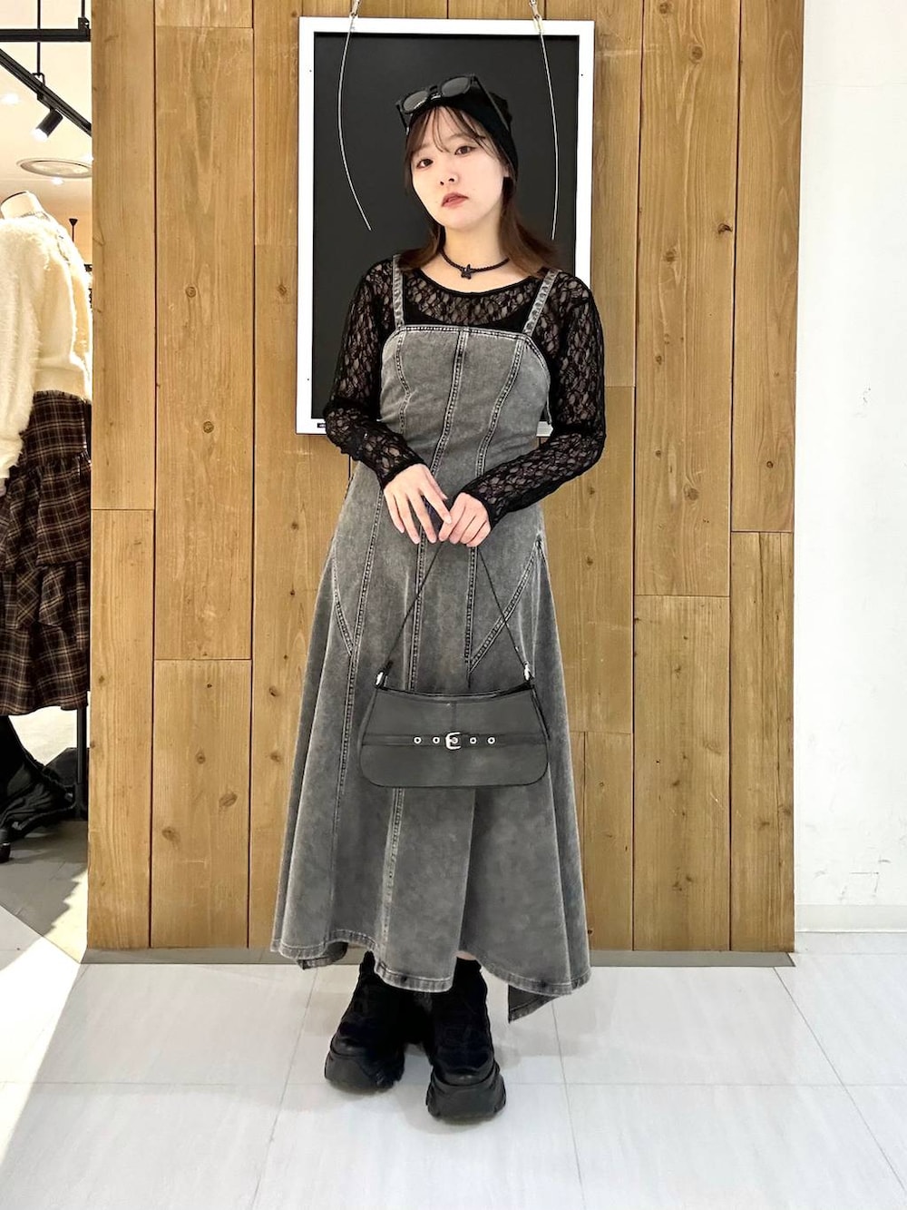 ブラック系のスニーカー、ブラック系のTシャツ/カットソー、ブラック系のハンドバッグを着用したレディースの冬コーディネートの2枚目の写真