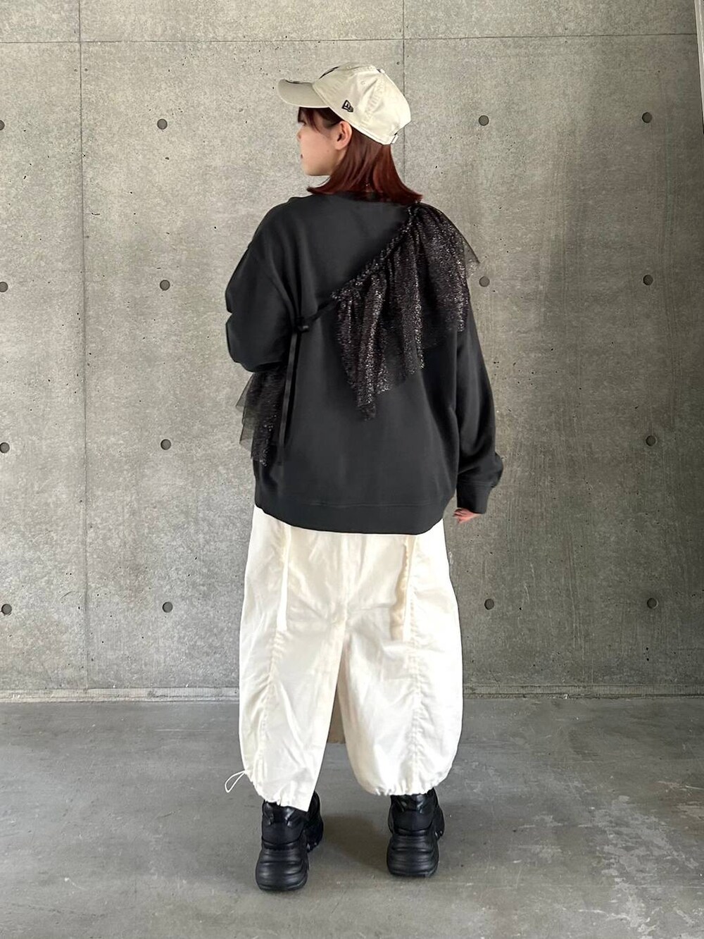 ブラック系のスニーカー、ホワイト系のスカート、ブラック系のスウェットを着用したレディースの春コーディネートの9枚目の写真