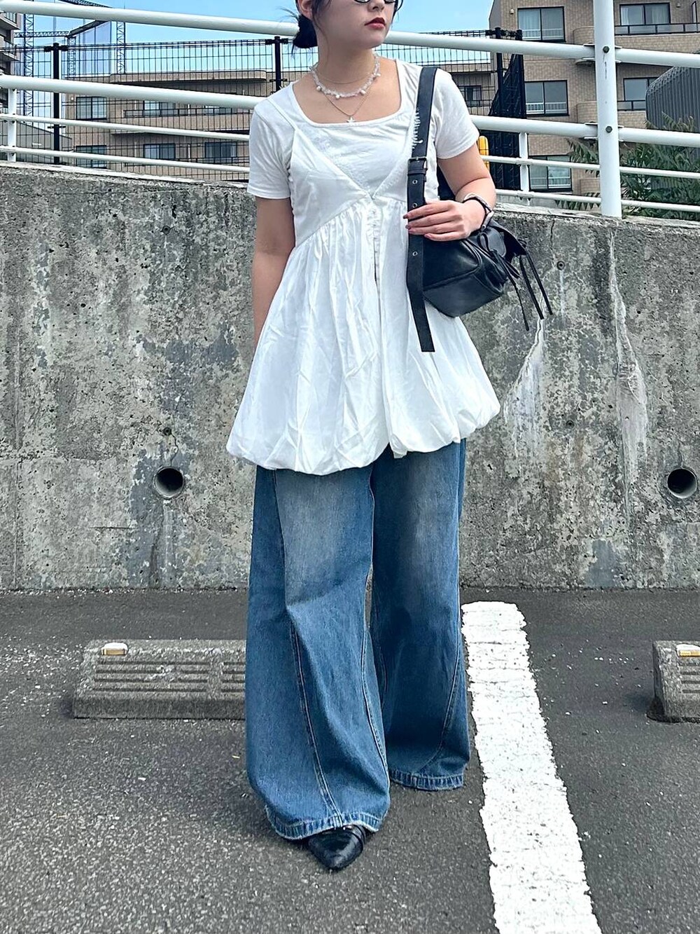 ブルー系のデニムパンツ、ホワイト系のTシャツ/カットソー、ホワイト系のキャミソールを着用したレディースの夏コーディネートの2枚目の写真