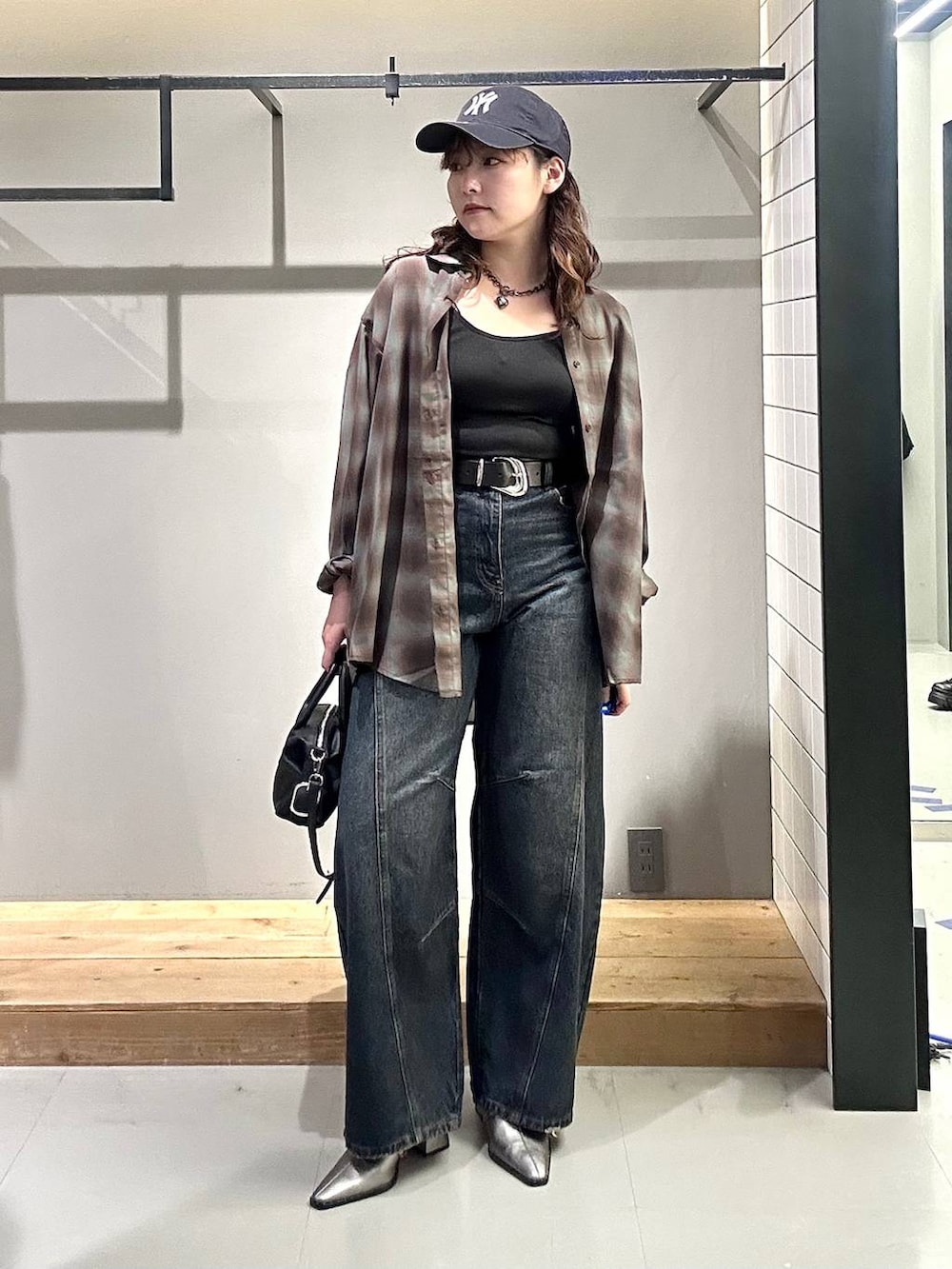 ブラック系のシャツ/ブラウス、ブルー系のデニムパンツ、ブラック系のショルダーバッグを着用したレディースの秋コーディネートの7枚目の写真