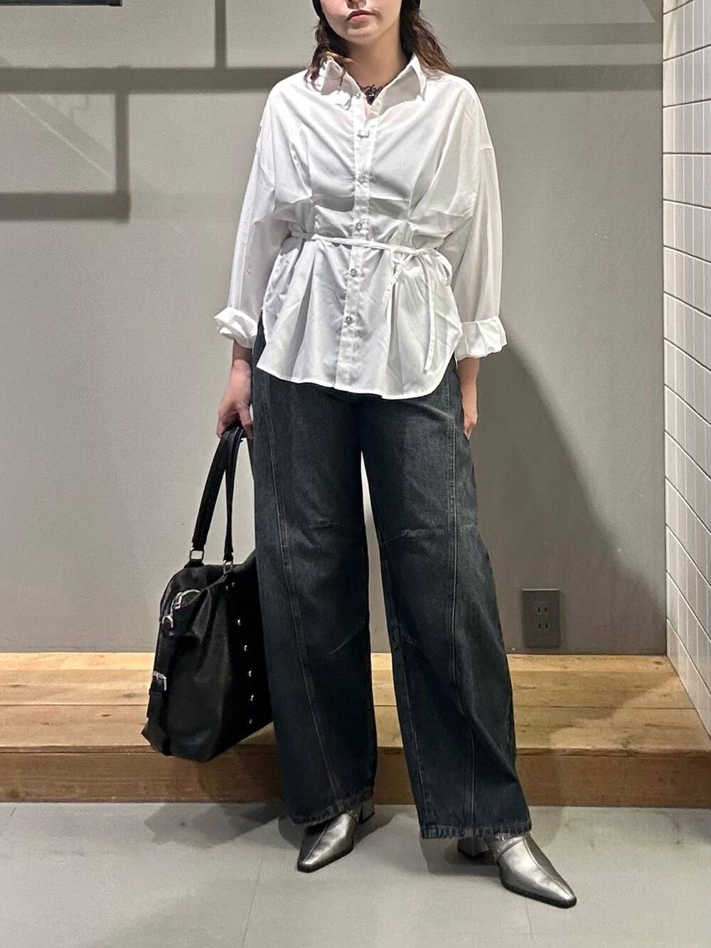 ブラック系のボストンバッグ、ブルー系のデニムパンツ、ホワイト系のシャツ/ブラウスを着用したレディースの秋コーディネートの2枚目の写真
