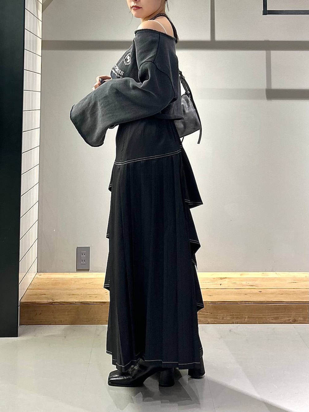 ブラック系のブーツ、ブラック系のスカート、グレー系のスウェットを着用したレディースの秋コーディネートの4枚目の写真