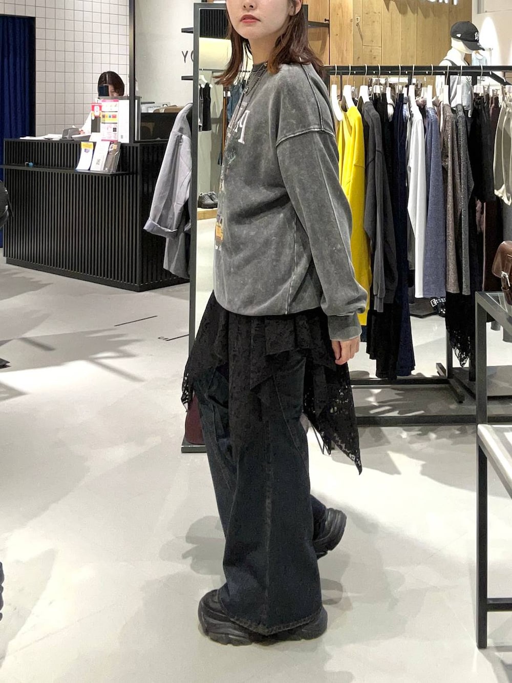 ブラック系のスニーカー、ブラック系のデニムパンツ、レッド系のボストンバッグを着用したレディースの秋コーディネートの6枚目の写真