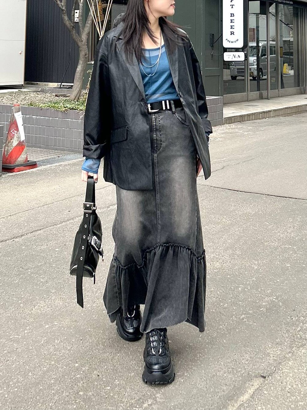 ブラック系のスニーカー、ブラック系のテーラードジャケット、ブラック系のショルダーバッグを着用したレディースの春コーディネートの3枚目の写真