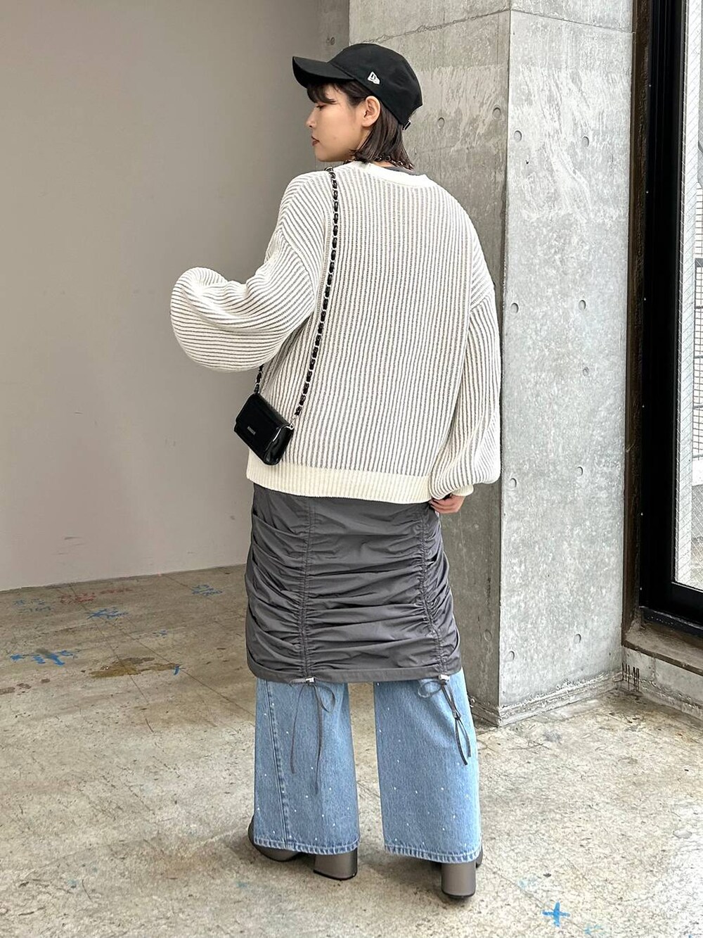 グレー系のワンピース、その他のブーツ、ブラック系のショルダーバッグを着用したレディースの冬コーディネートの5枚目の写真