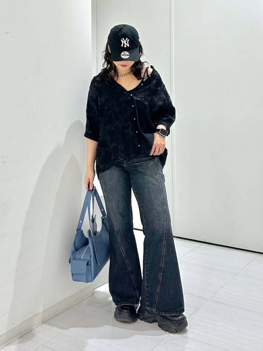 ブラック系のキャミソール、ブルー系のデニムパンツ、ブルー系のハンドバッグを着用したレディースの夏コーディネートの8枚目の写真