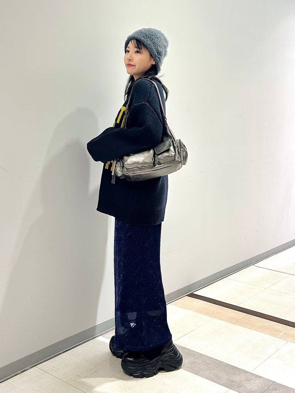 ブラック系のブーツ、その他のショルダーバッグ、ブルー系のニット/セーターを着用したレディースの秋コーディネートの4枚目の写真