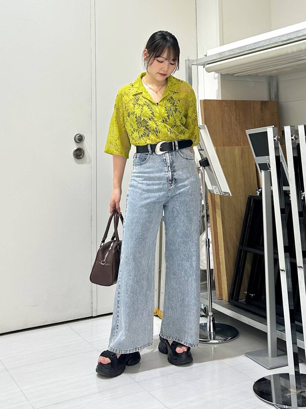 ブラック系のサンダル、ブラック系のキャミソール、ブルー系のデニムパンツを着用したレディースの夏コーディネートの3枚目の写真