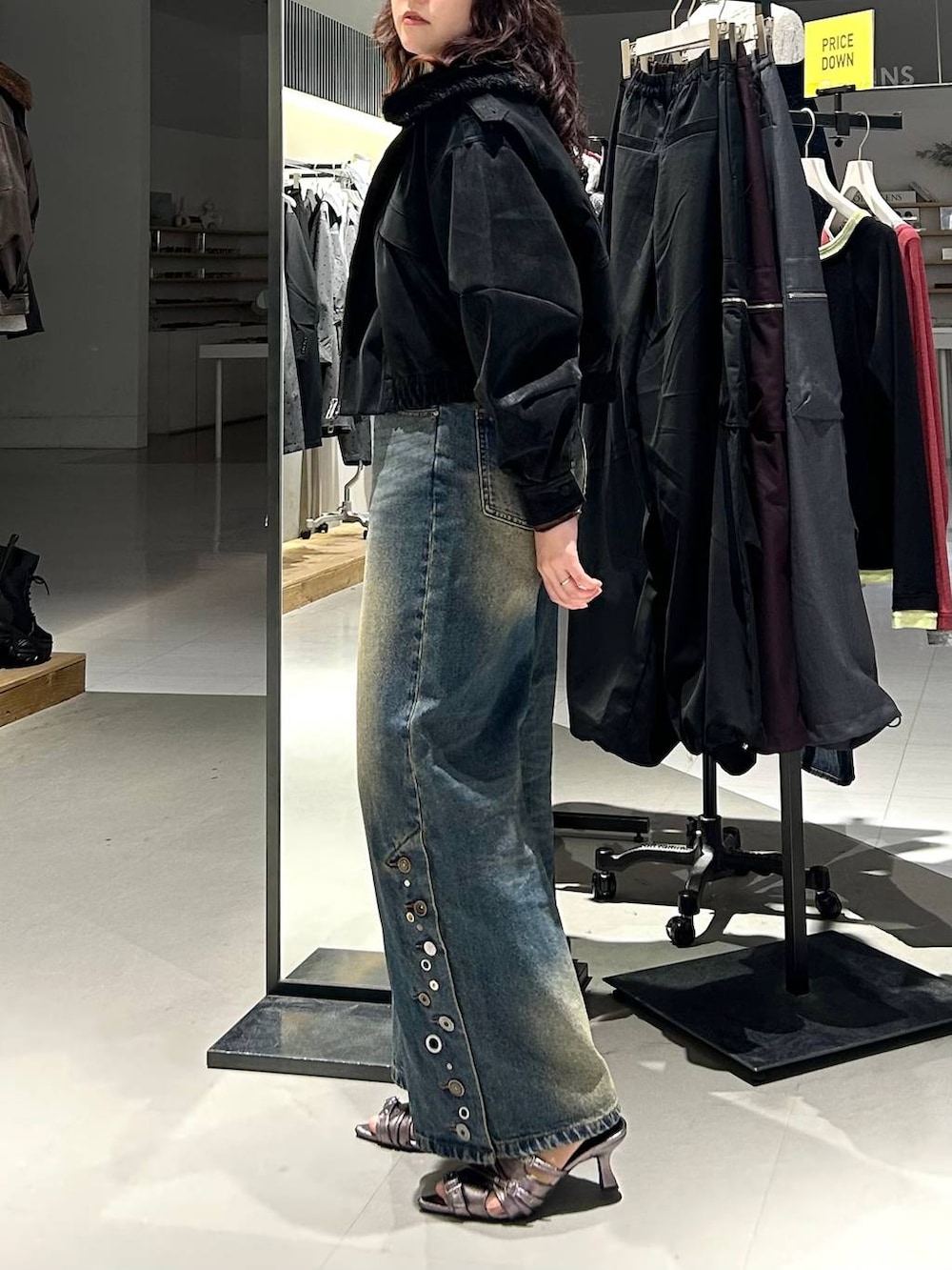 ブラック系のブルゾン、ブルー系のデニムパンツ、ブラウン系のTシャツ/カットソーを着用したレディースの秋コーディネートの6枚目の写真