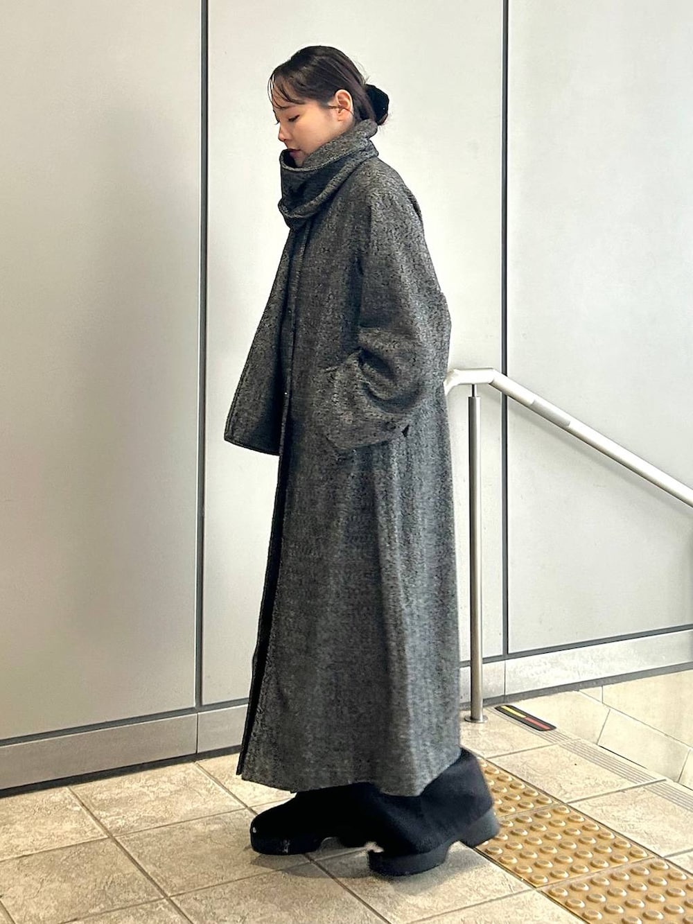 ブラック系のチェスターコート、ブラック系のスラックス、ブラック系のショルダーバッグを着用したレディースの冬コーディネートの7枚目の写真