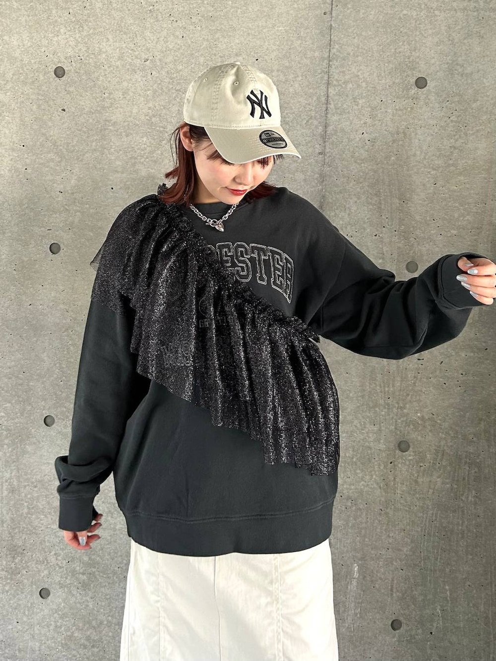 ブラック系のスニーカー、ホワイト系のスカート、ブラック系のスウェットを着用したレディースの春コーディネートの2枚目の写真