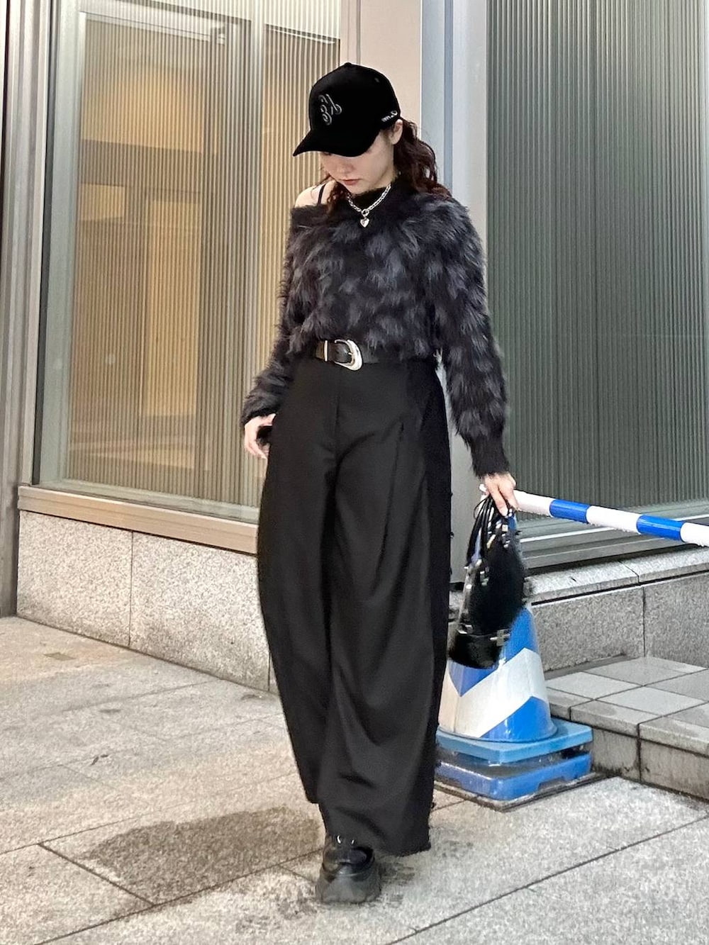ブラック系のニット/セーター、ブラック系のスニーカー、ブラック系のショルダーバッグを着用したレディースの秋コーディネートの2枚目の写真