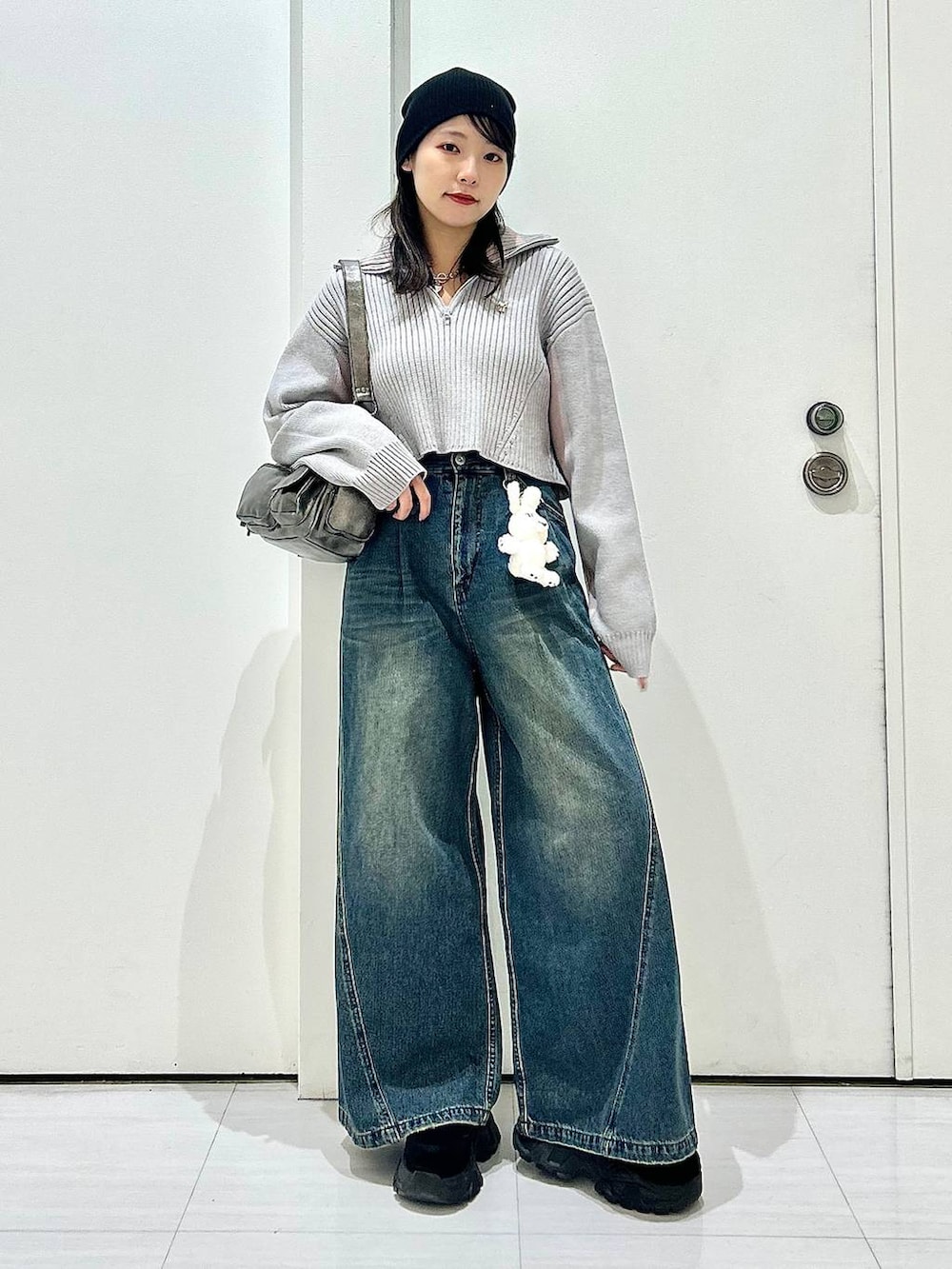 ブルー系のデニムパンツ、グレー系のショルダーバッグ、グレー系のニット/セーターを着用したレディースの秋コーディネートの7枚目の写真