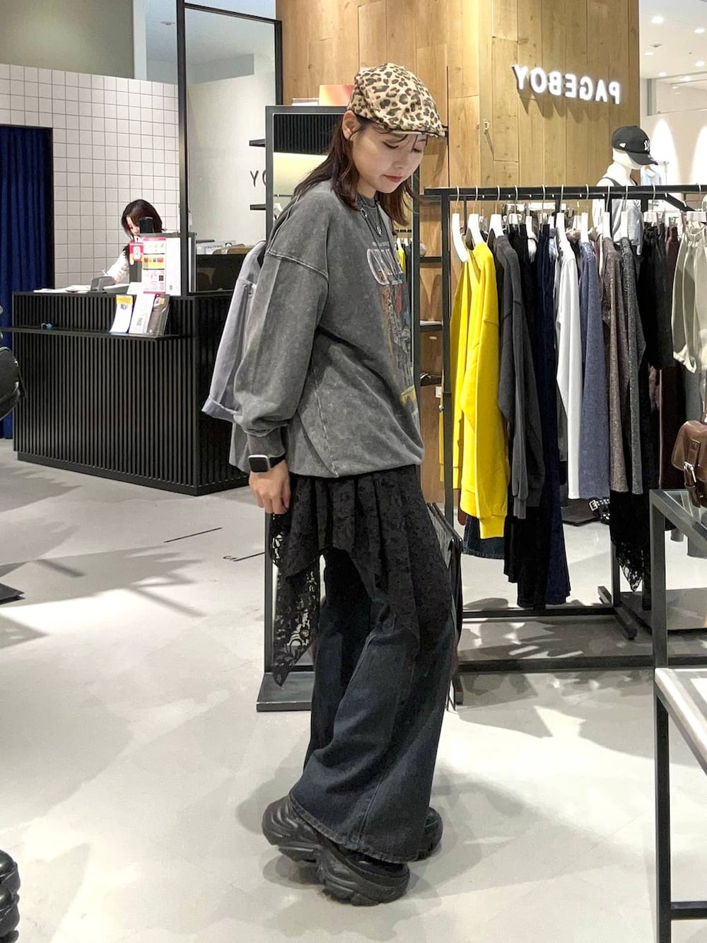 ブラック系のスニーカー、ブラック系のデニムパンツ、レッド系のボストンバッグを着用したレディースの秋コーディネートの4枚目の写真