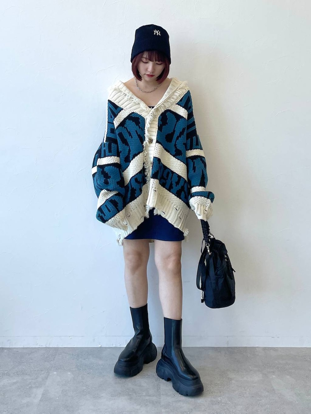 ブラック系のキャミソール、ブラック系のブーツ、ブルー系のスカートを着用したレディースの秋コーディネートの6枚目の写真