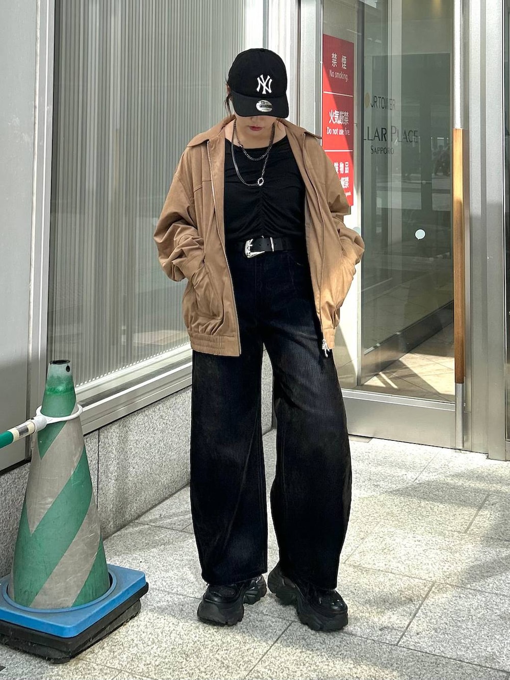 ブラック系のデニムパンツ、イエロー系のブルゾン、ブラック系のTシャツ/カットソーを着用したレディースの秋コーディネートの3枚目の写真