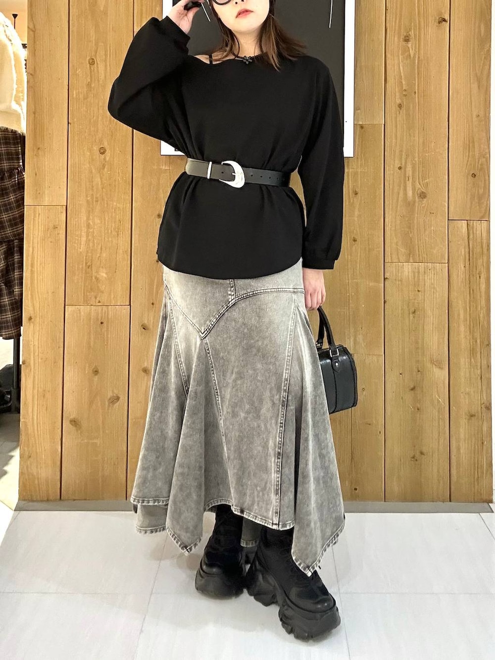 ブラック系のスニーカー、ブラック系のボストンバッグ、ブラック系のTシャツ/カットソーを着用したレディースの冬コーディネートの3枚目の写真