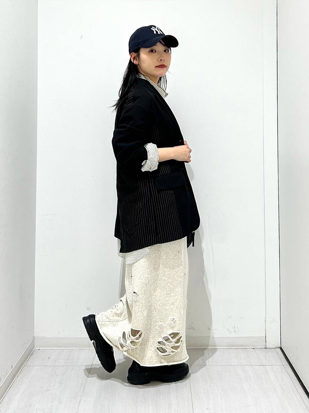 ブラック系のスニーカー、ブラック系のテーラードジャケット、ブラック系のショルダーバッグを着用したレディースの春コーディネートの5枚目の写真