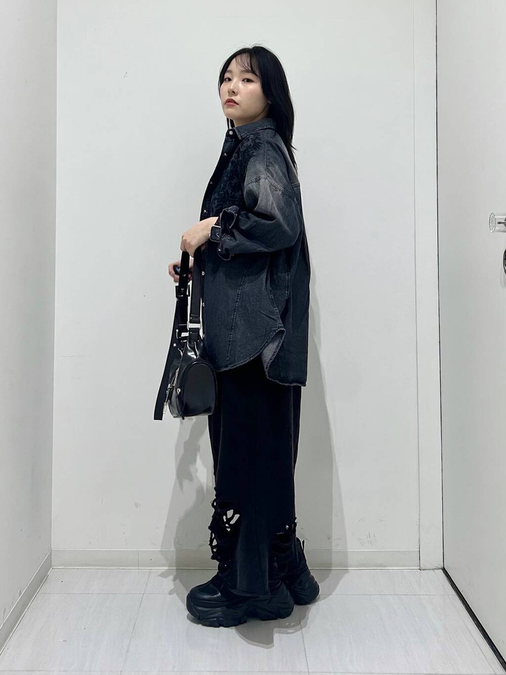 ブラック系のスニーカー、ブラック系のショルダーバッグ、ブラック系のシャツ/ブラウスを着用したレディースの春コーディネートの5枚目の写真