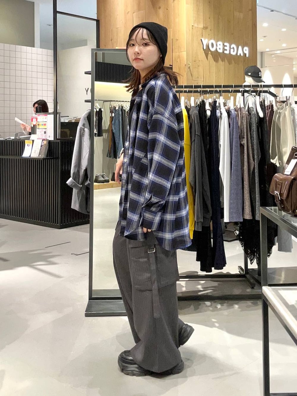 ブラック系のスニーカー、ブルー系のシャツ/ブラウス、グレー系のスラックスを着用したレディースの秋コーディネートの4枚目の写真