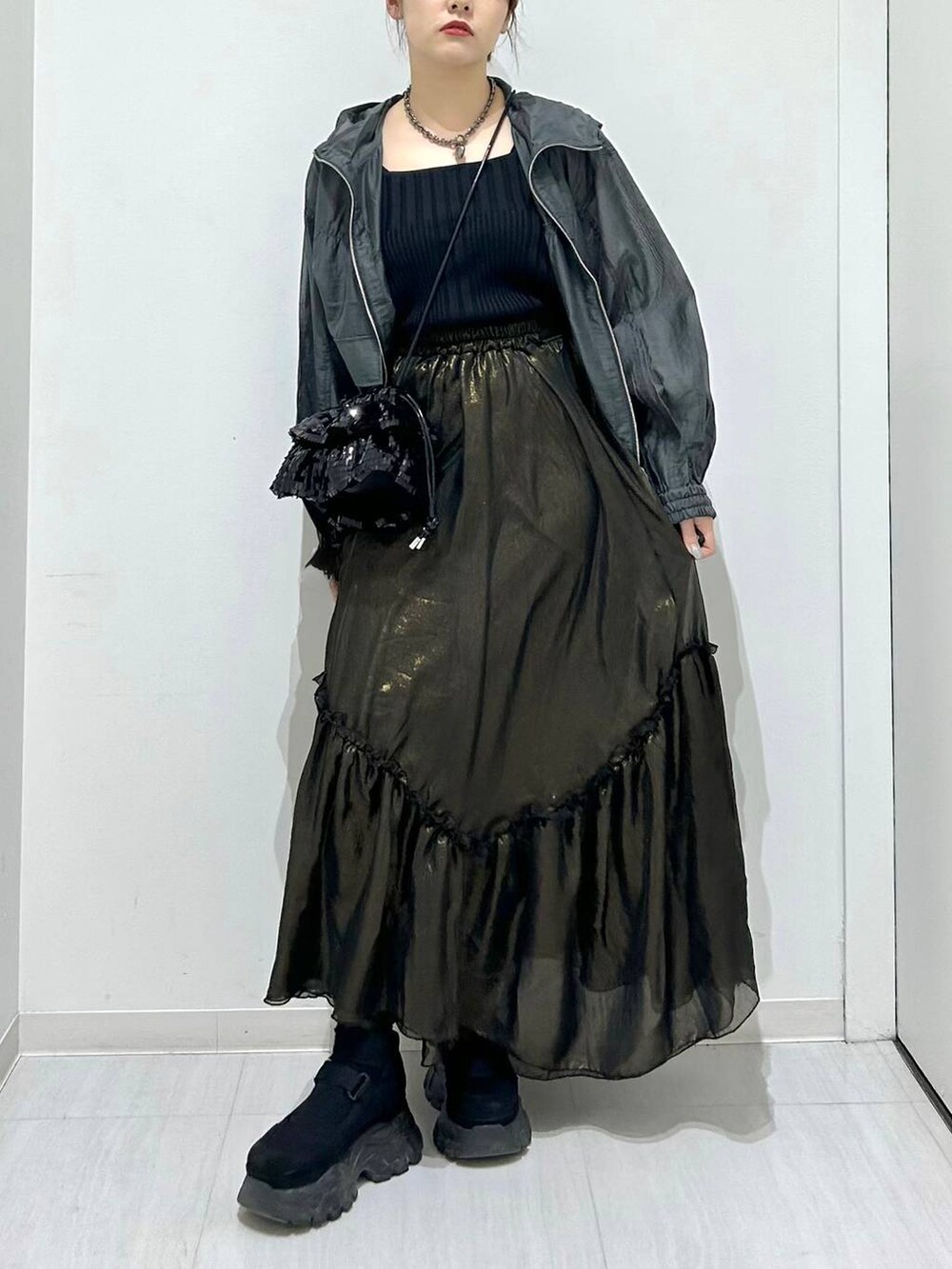 ブラック系のタンクトップ、ブラック系のスカート、グレー系のブルゾンを着用したレディースの春コーディネートの3枚目の写真