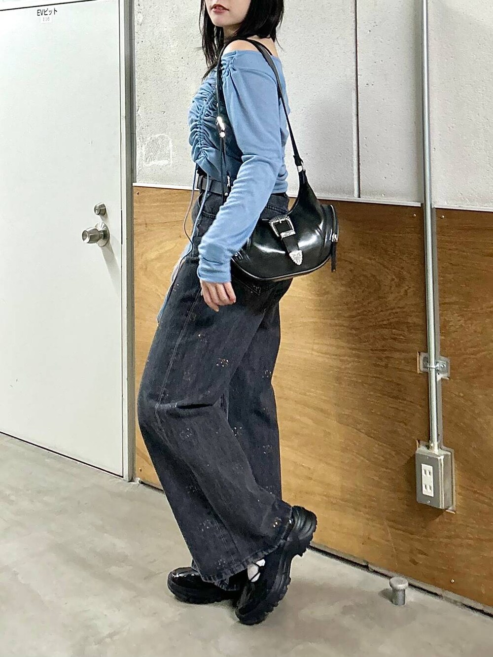 ブラック系のデニムパンツ、ブラック系のスニーカー、ブラック系のショルダーバッグを着用したレディースの春コーディネートの8枚目の写真