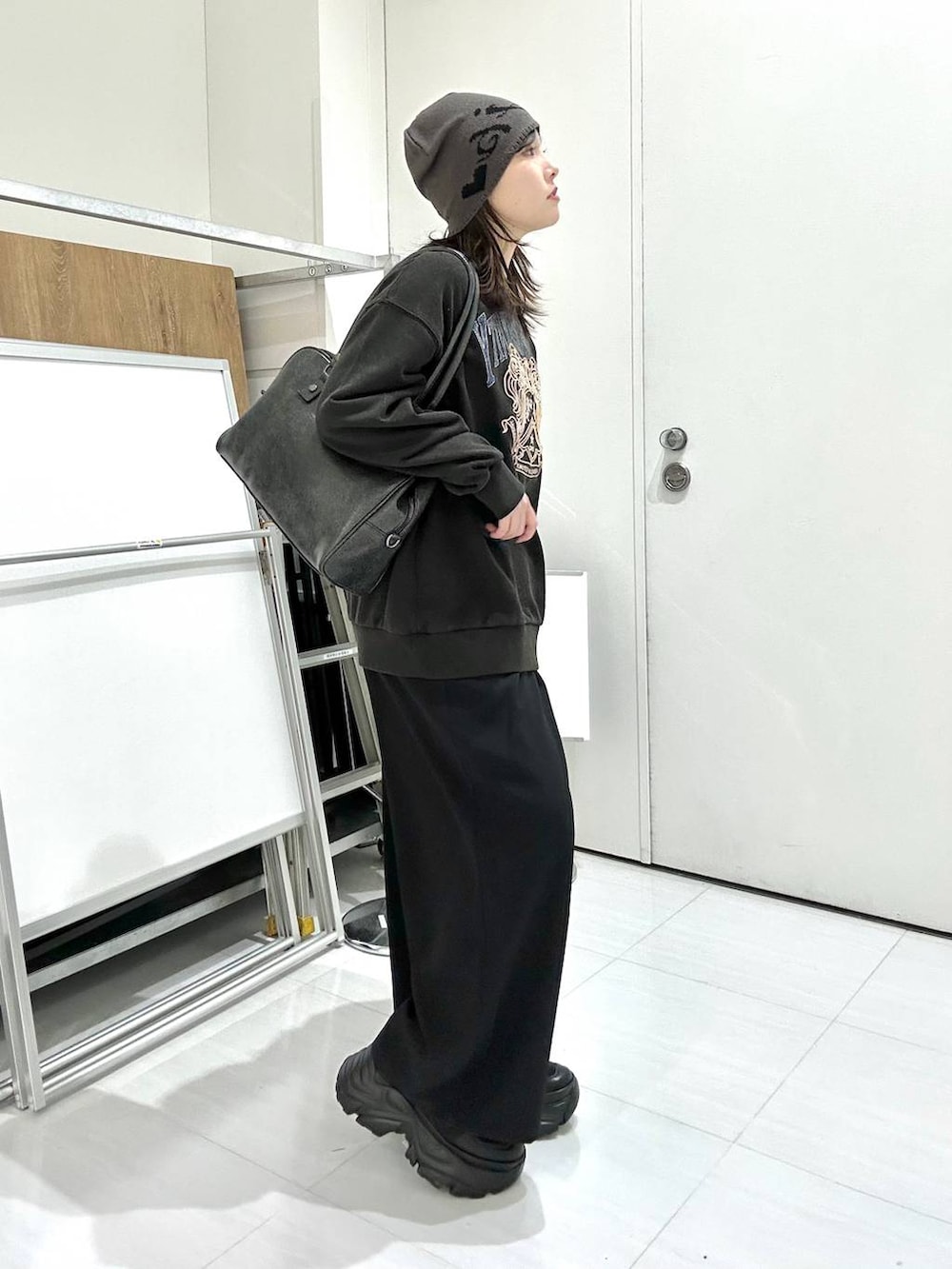 ブラック系のスニーカー、グレー系のボストンバッグ、グレー系のスウェットを着用したレディースの冬コーディネートの4枚目の写真