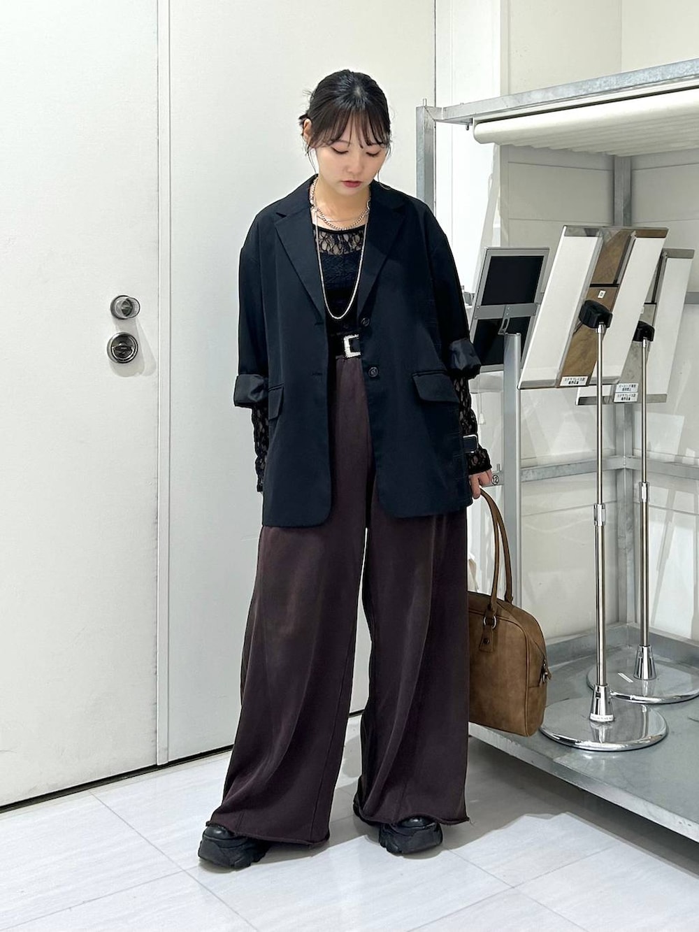 ベージュ系のボストンバッグ、ブラック系のスウェットパンツ、ブラック系のテーラードジャケットを着用したレディースの秋コーディネートの2枚目の写真