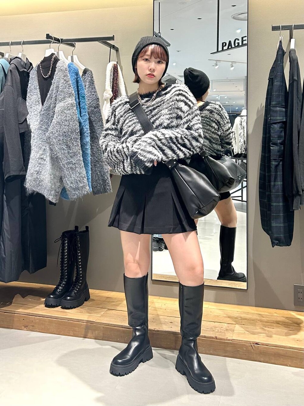 ブラック系のブーツ、ブラック系のショルダーバッグ、その他のカーディガン/ボレロを着用したレディースの秋コーディネートの2枚目の写真