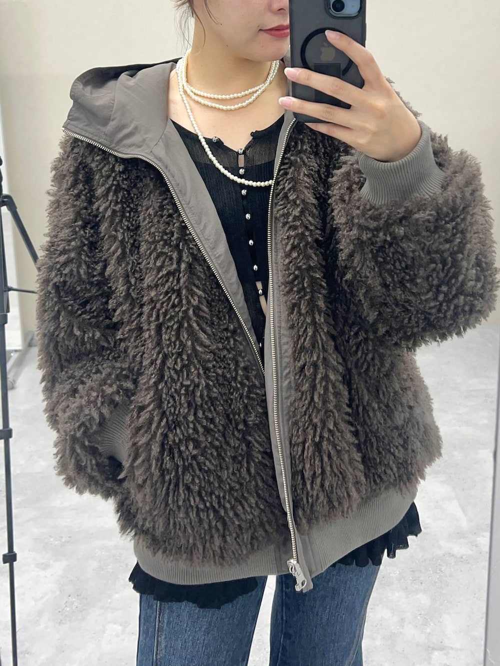 ブルー系のデニムパンツ、ブラウン系のブルゾンを着用したレディースの秋コーディネートの4枚目の写真