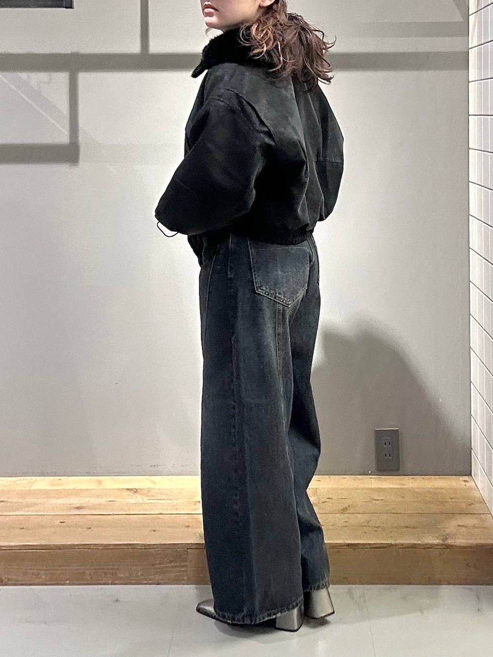 ブルー系のデニムパンツ、グレー系のTシャツ/カットソー、ブラック系のブルゾンを着用したレディースの秋コーディネートの4枚目の写真