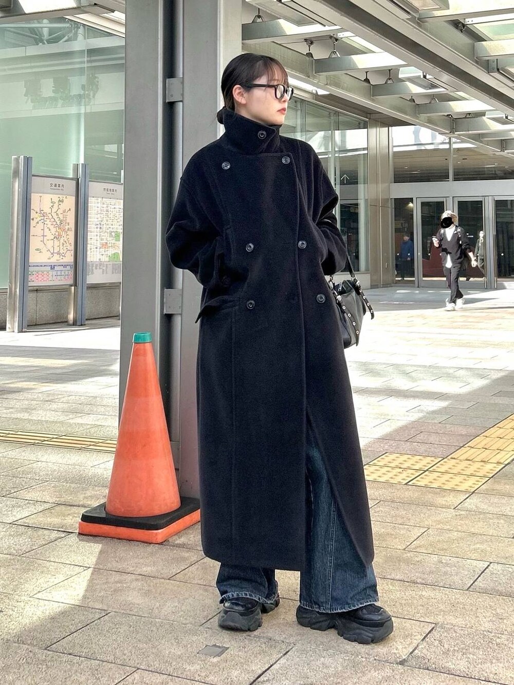 ブラック系のスニーカー、ブルー系のデニムパンツ、ブラック系のボストンバッグを着用したレディースの秋コーディネートの7枚目の写真