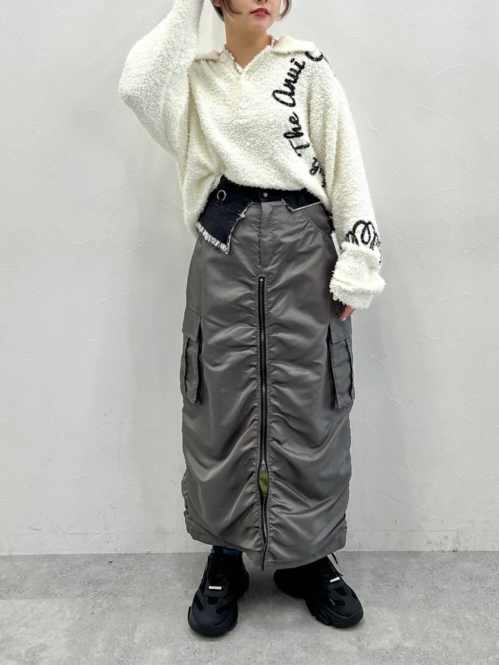 グレー系のスカート、ホワイト系のニット/セーターを着用したレディースの冬コーディネートの3枚目の写真