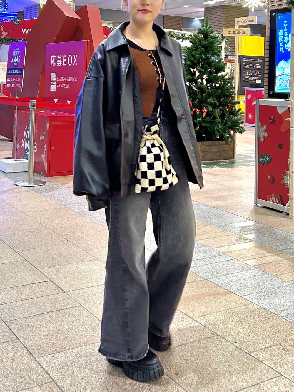 ブラック系のデニムパンツ、ブラック系のブルゾン、ブラック系のブーツを着用したレディースの秋コーディネートの2枚目の写真