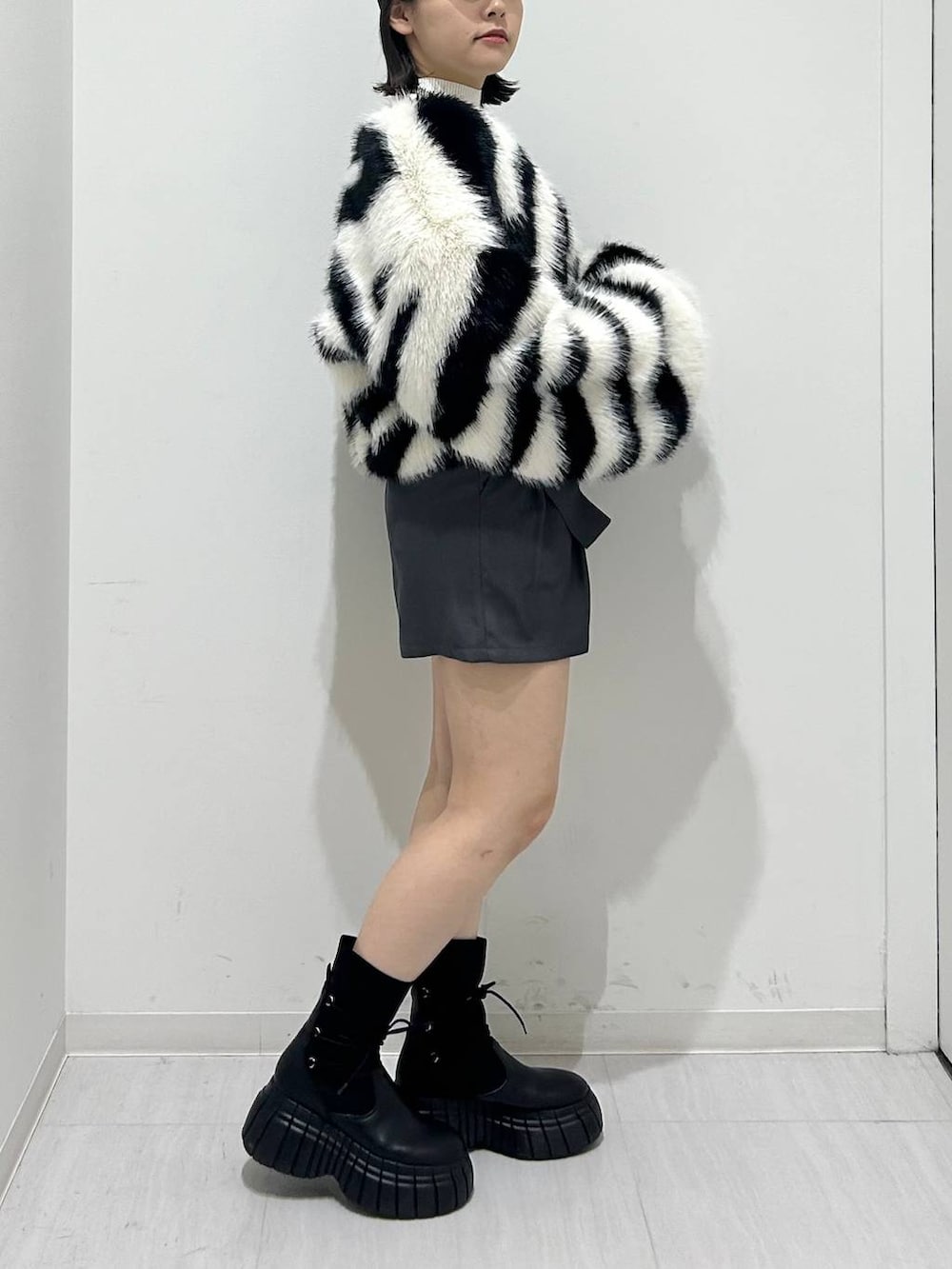 ホワイト系のニット/セーター、ブラック系のショルダーバッグ、ホワイト系のブルゾンを着用したレディースの秋コーディネートの4枚目の写真