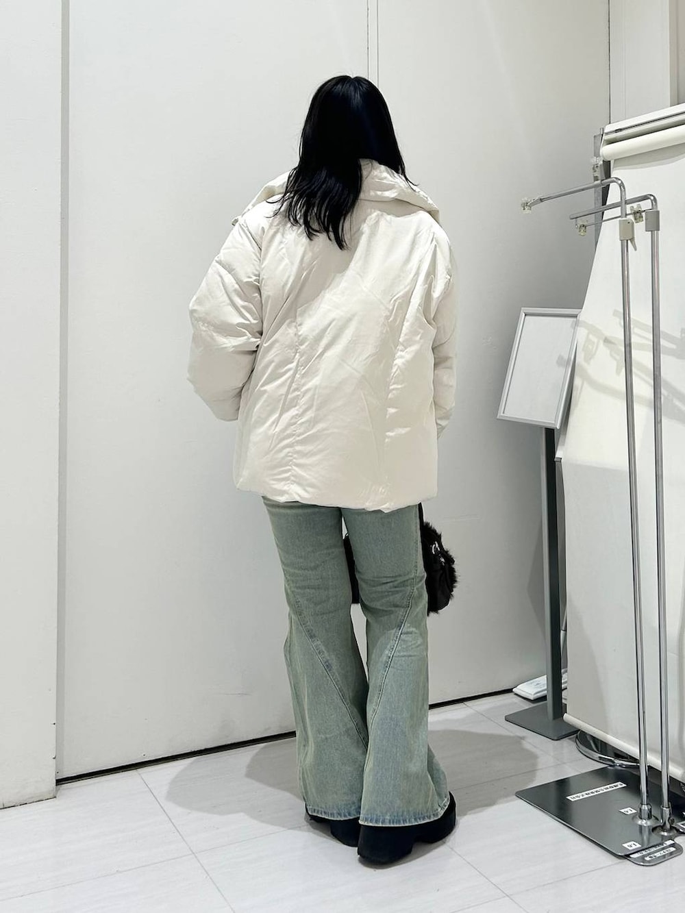 ブルー系のデニムパンツ、ホワイト系のブルゾン、ブラック系のブーツを着用したレディースの冬コーディネートの4枚目の写真