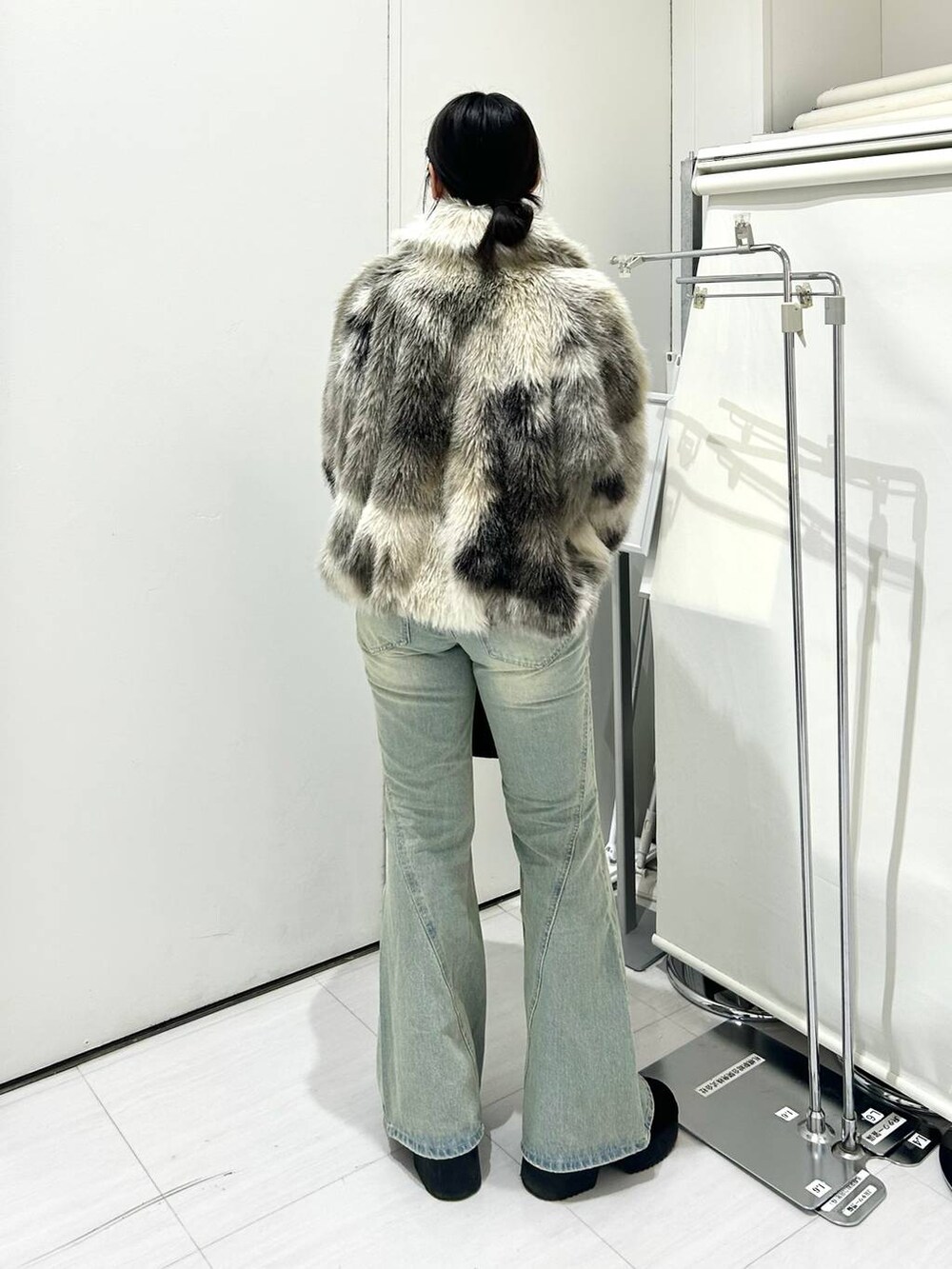 グレー系のブルゾン、ブルー系のデニムパンツ、ホワイト系のニット/セーターを着用したレディースの冬コーディネートの4枚目の写真
