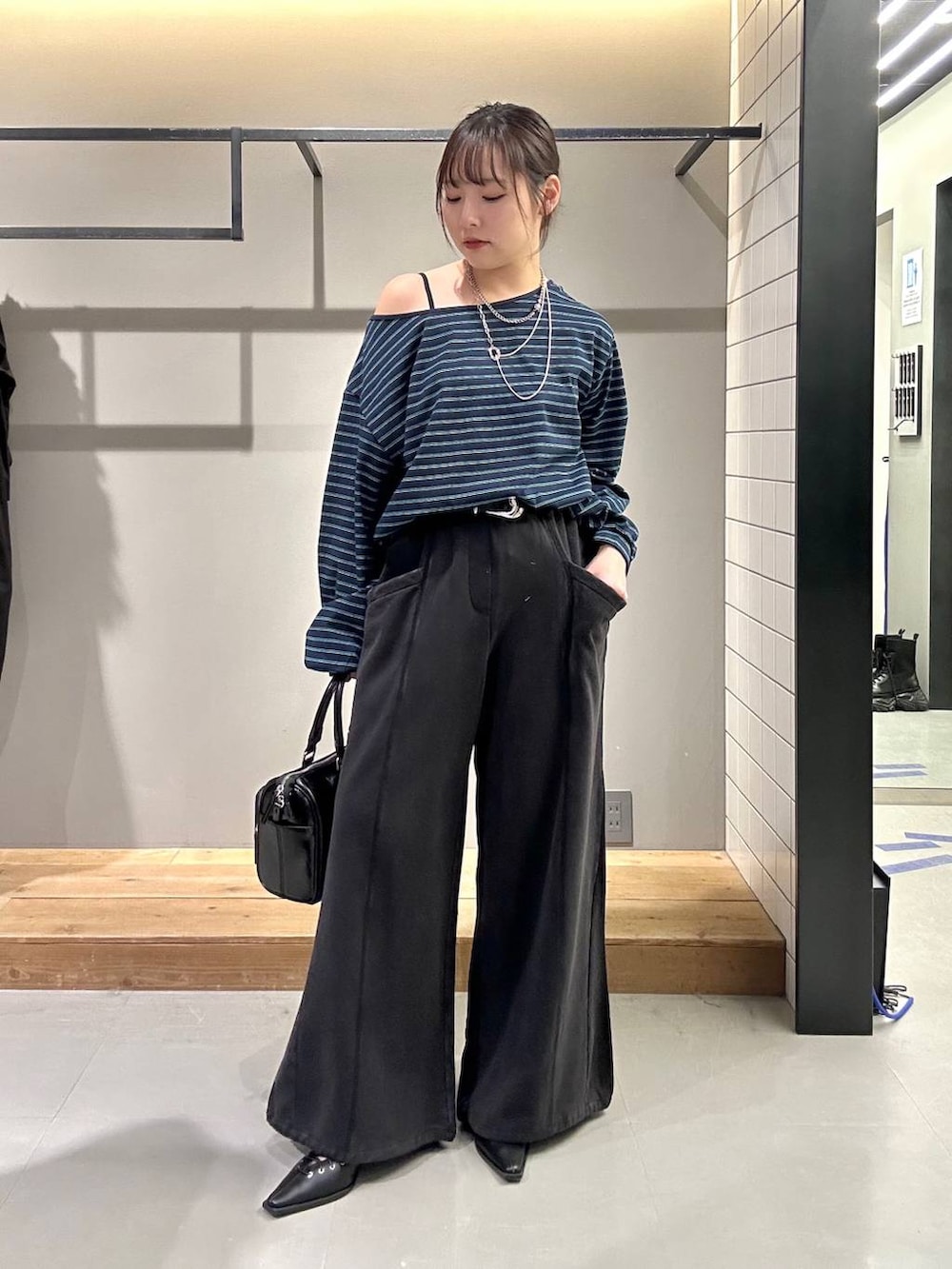 ブラック系のスウェットパンツ、ブラック系のショルダーバッグ、ブラック系のサンダルを着用したレディースの冬コーディネートの2枚目の写真