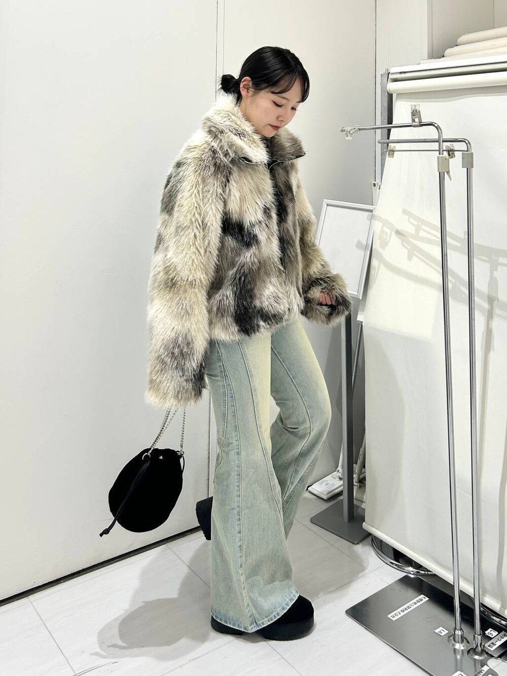グレー系のブルゾン、ブルー系のデニムパンツ、ホワイト系のニット/セーターを着用したレディースの冬コーディネートの3枚目の写真