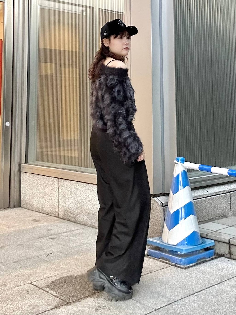 ブラック系のニット/セーター、ブラック系のスニーカー、ブラック系のショルダーバッグを着用したレディースの秋コーディネートの5枚目の写真