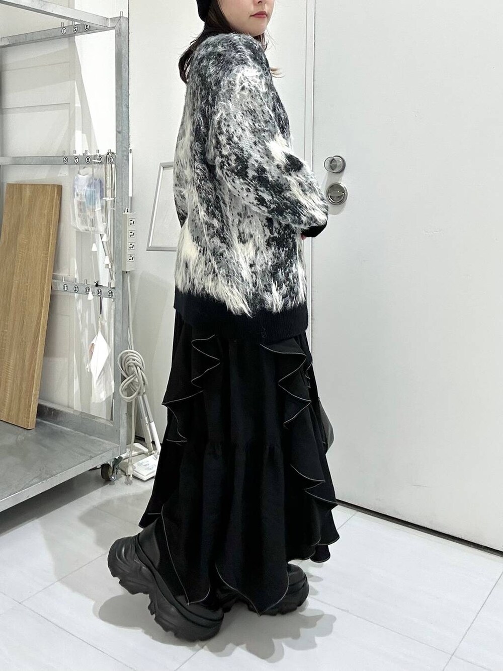 ブラック系のブーツ、ブラック系のカーディガン/ボレロ、ブラック系のスカートを着用したレディースの冬コーディネートの4枚目の写真