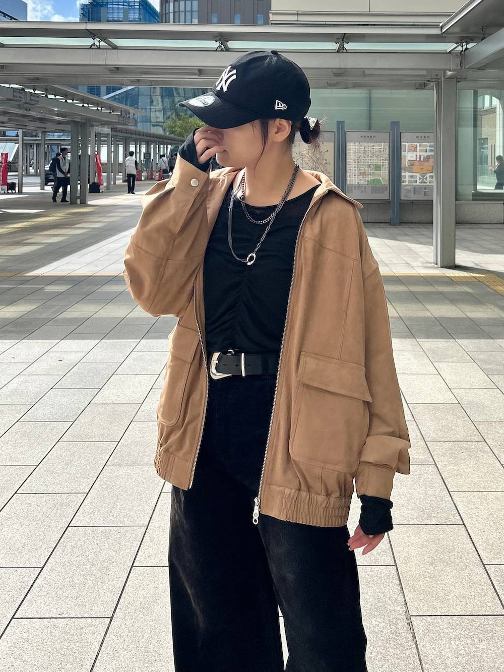 ブラック系のデニムパンツ、イエロー系のブルゾン、ブラック系のTシャツ/カットソーを着用したレディースの秋コーディネートの2枚目の写真