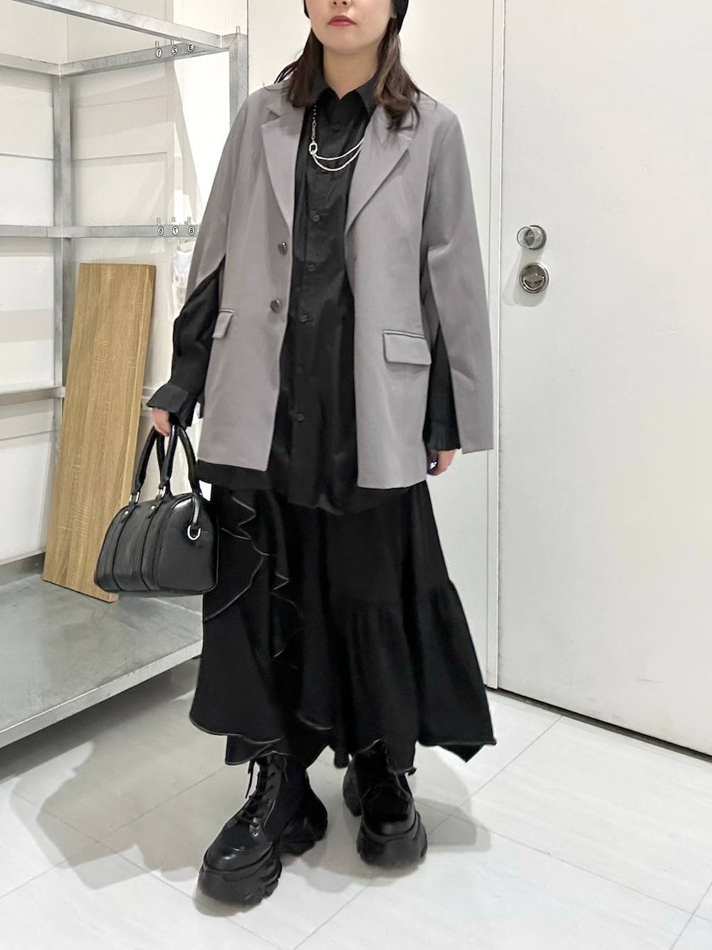 ブラック系のブーツ、グレー系のテーラードジャケット、ブラック系のスカートを着用したレディースの冬コーディネートの3枚目の写真