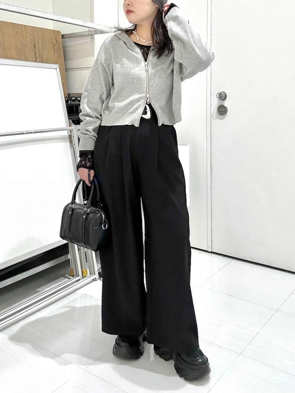 ブラック系のスニーカー、ブラック系のTシャツ/カットソー、ブラック系のボストンバッグを着用したレディースの冬コーディネートの3枚目の写真