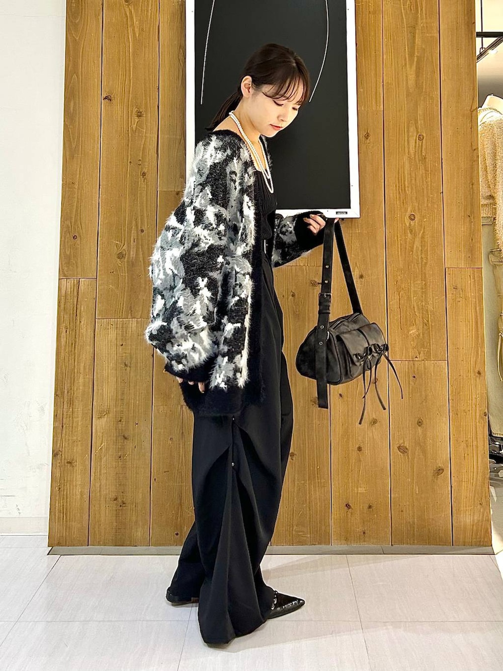 ブラック系のタンクトップ、ブラック系のパンプス、ブラック系のショルダーバッグを着用したレディースの秋コーディネートの6枚目の写真