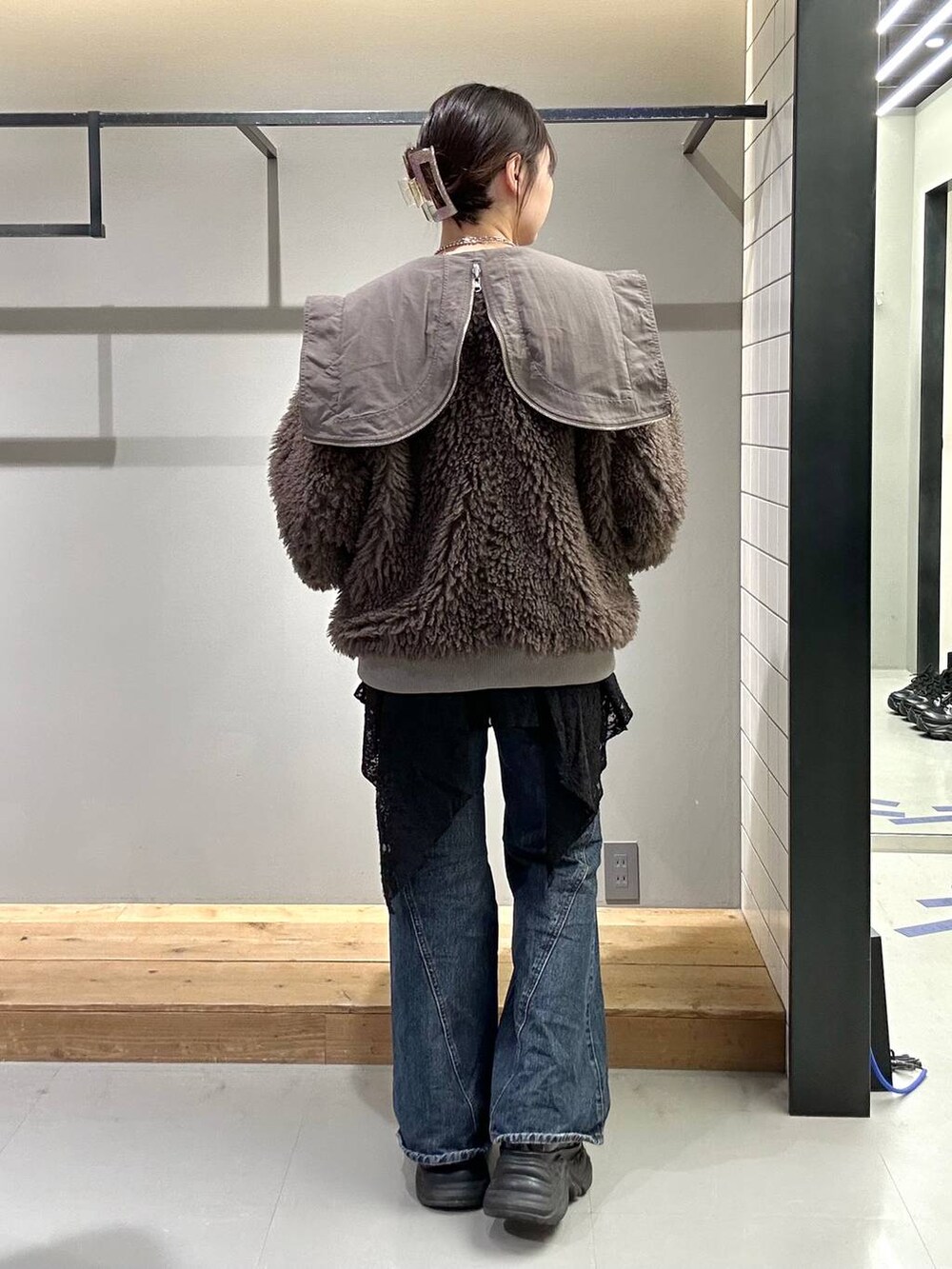 ブラック系のスニーカー、ブルー系のデニムパンツ、ブラック系のブルゾンを着用したレディースの秋コーディネートの5枚目の写真