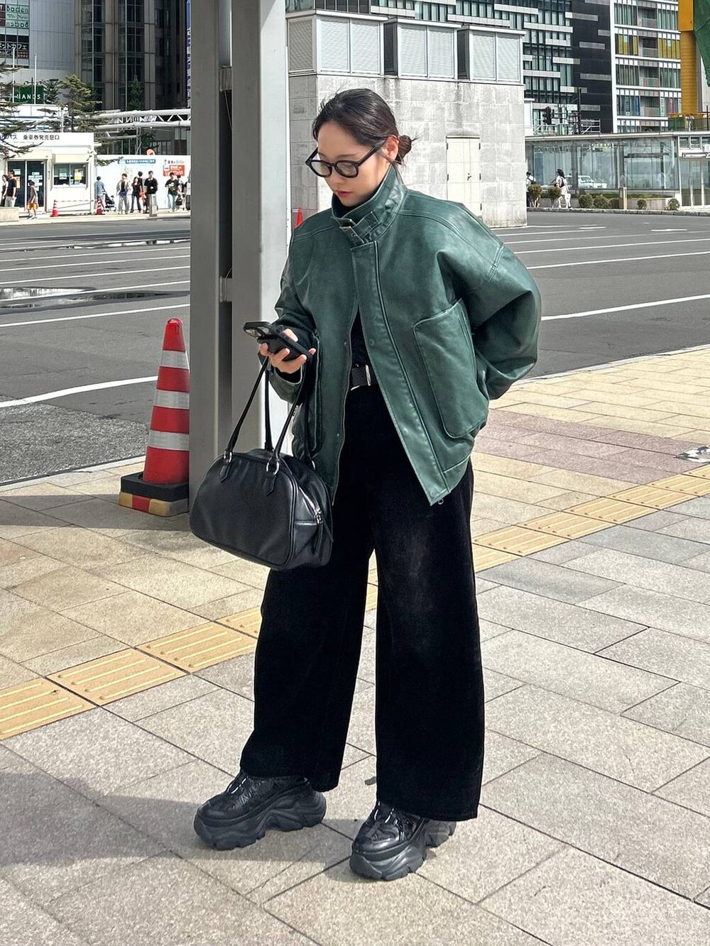 ブラック系のデニムパンツ、グリーン系のブルゾンを着用したレディースの秋コーディネートの6枚目の写真