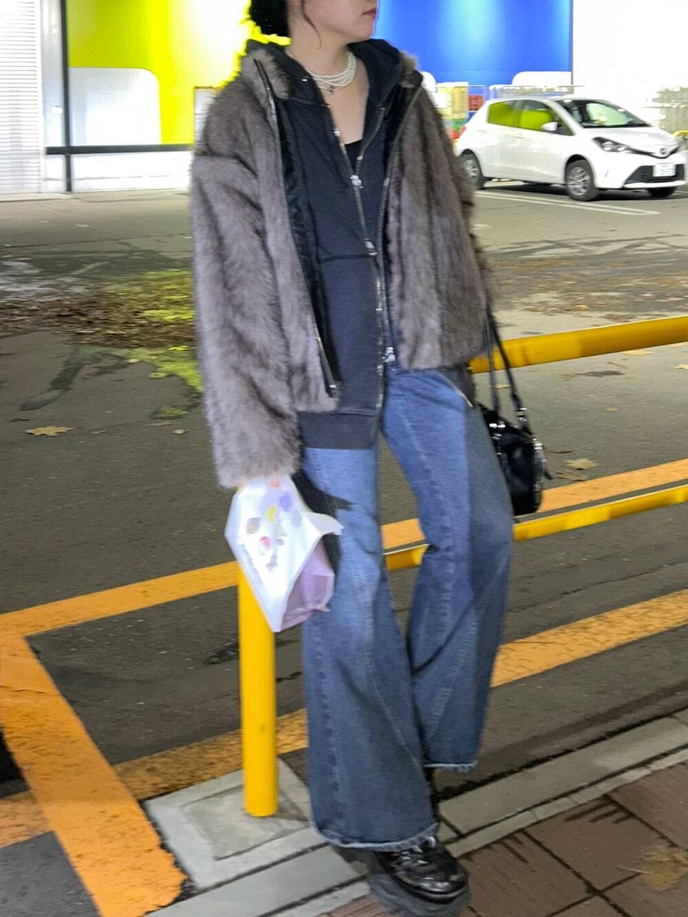 ブルー系のデニムパンツ、ブラック系のパーカー、ブラウン系のブルゾンを着用したレディースの秋コーディネートの3枚目の写真