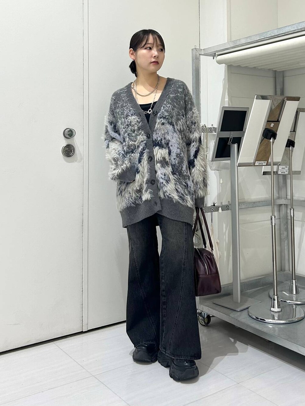 ブラック系のスニーカー、ブルー系のデニムパンツ、レッド系のボストンバッグを着用したレディースの秋コーディネートの2枚目の写真