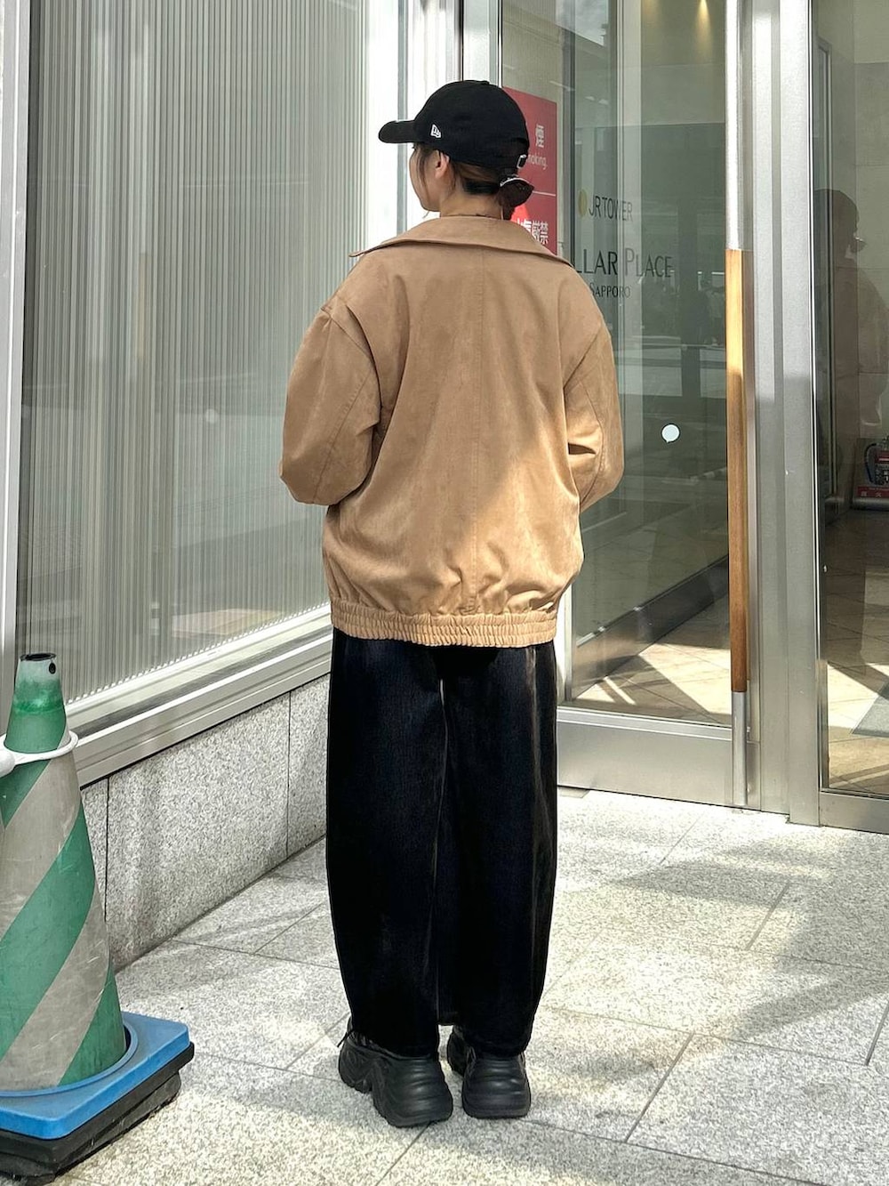 ブラック系のデニムパンツ、イエロー系のブルゾン、ブラック系のTシャツ/カットソーを着用したレディースの秋コーディネートの6枚目の写真